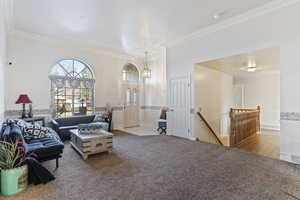 Living room featuring crown molding and light colored carpet