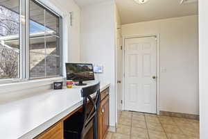 Tiled home office featuring built in desk and a wealth of natural light