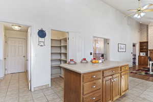 Kitchen with light tile patterned floors, a center island, and ceiling fan