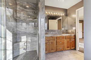 Bathroom featuring tile patterned floors, vanity, and a shower with door