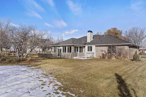 Snow covered house featuring a lawn