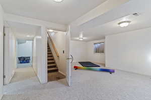 Exercise area with light colored carpet and a textured ceiling