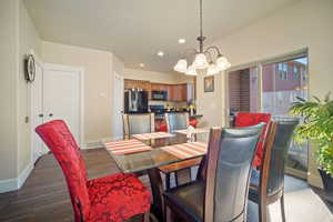 Dining space with dark wood-type flooring and a notable chandelier