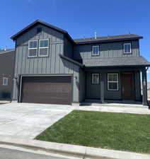 View of front of house with covered porch, a shingled roof, board and batten siding, concrete driveway, and an attached garage