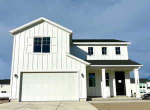 Modern farmhouse style home with a garage and a porch