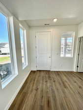 Foyer with light hardwood / wood-style flooring and a textured ceiling