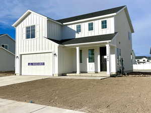 View of front of property featuring a garage and covered porch