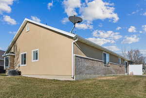 View of property exterior featuring central AC unit and a lawn