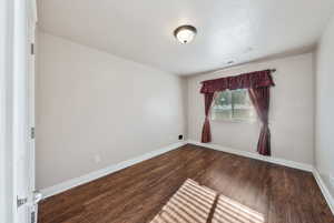 Unfurnished room featuring dark hardwood / wood-style floors