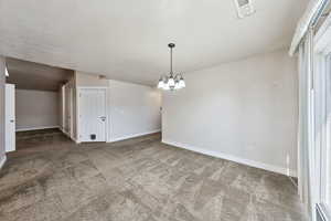 Unfurnished dining area with carpet flooring and an inviting chandelier