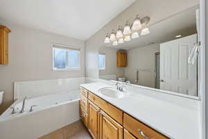 Bathroom featuring vanity, a bathtub, tile patterned floors, and toilet