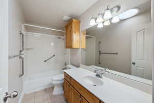 Full bathroom with tile patterned flooring, vanity,  shower combination, and toilet