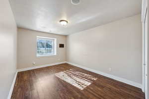 Unfurnished room featuring dark hardwood / wood-style floors