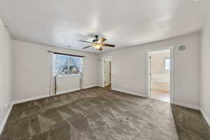 Carpeted spare room featuring ceiling fan