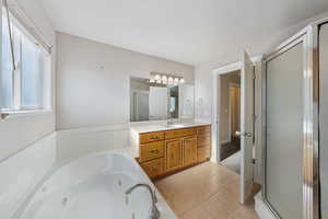 Bathroom with tile patterned flooring, vanity, and plus walk in shower