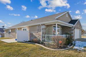 View of front of property featuring a porch, a garage, and a front yard