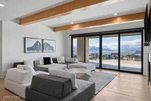 Living room with beamed ceiling and light wood-type flooring