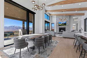 Dining area featuring beamed ceiling, a large fireplace, a chandelier, hardwood / wood-style flooring, and a mountain view