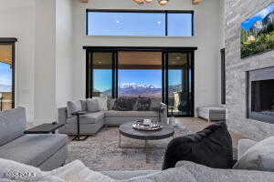 Living room featuring a high end fireplace, plenty of natural light, and a high ceiling