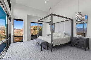 Bedroom with high vaulted ceiling and carpet