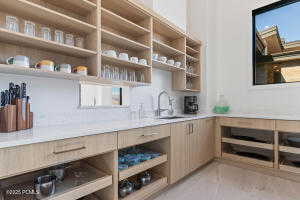 Bar featuring sink, light tile patterned floors, and light brown cabinetry