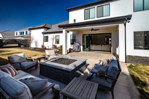 Rear view of property with an outdoor living space with a fire pit, ceiling fan, and a patio area