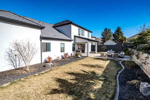 Rear view of property featuring an outdoor hangout area, a yard, and a patio area