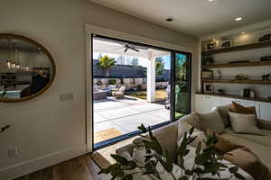 Doorway to outside with light hardwood / wood-style flooring, built in features, and ceiling fan