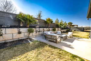 View of yard featuring an outdoor living space with a fire pit and a patio area