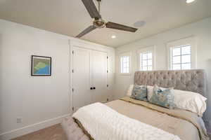 Carpeted bedroom featuring a closet and ceiling fan