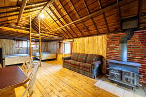 Interior space with lofted ceiling with beams, wooden walls, and wooden ceiling