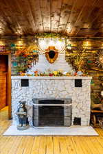 Interior details featuring hardwood / wood-style floors, wood ceiling, and a fireplace