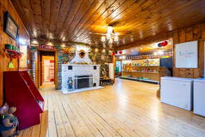 Interior space featuring ceiling fan, wooden ceiling, independent washer and dryer, light hardwood / wood-style floors, and a fireplace