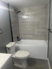 Full bathroom featuring toilet, vanity, and tiled shower / bath