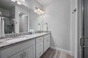 Bathroom with a shower with door, vanity, and hardwood / wood-style floors