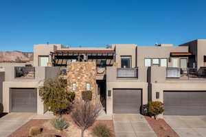 Pueblo-style home featuring a balcony and a mountain view