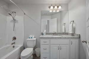 Full bathroom with washtub / shower combination, vanity, and toilet