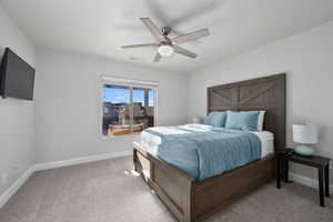 Carpeted bedroom featuring ceiling fan