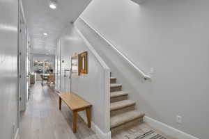 Stairway featuring wood-type flooring and a textured ceiling