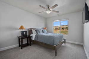 Bedroom with light colored carpet, a textured ceiling, and ceiling fan