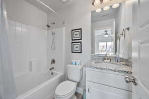 Full bathroom with washtub / shower combination, vanity, and toilet