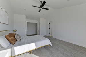 Bedroom with lofted ceiling, ceiling fan, and carpet floors