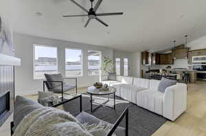 Living room with a healthy amount of sunlight, lofted ceiling, and light hardwood / wood-style floors