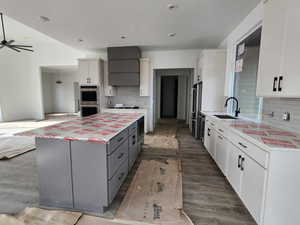 Kitchen with light countertops, a center island, appliances with stainless steel finishes, and a sink