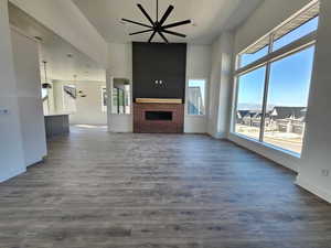 Gorgeous living room with a towering ceiling, fireplace, and laminate flooring. Huge windows to enjoy all the natural light