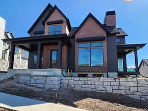 View of front of home with covered porch and brick siding