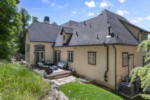 Rear view of house with an outdoor hangout area, stucco siding, a wooden deck, a chimney, and a lawn