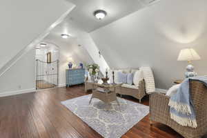 Sitting room with dark wood-type flooring and vaulted ceiling