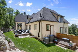 Rear view of property with an outdoor hangout area, a deck, stucco siding, and a chimney
