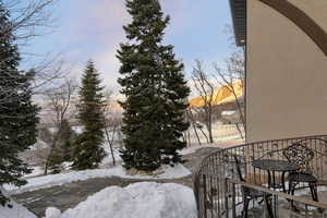 Snow covered back of property featuring a water view